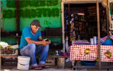 Un hombre sonriente usando un smartphone con internet comunitario